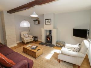 a living room with a couch and a fire place at The Cottage in Chipping Campden