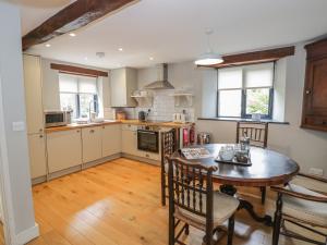 a kitchen with a wooden table and a dining room at The Cottage in Chipping Campden