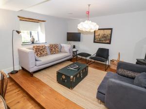 a living room with a couch and a table at The Old Stables in Chipping Campden