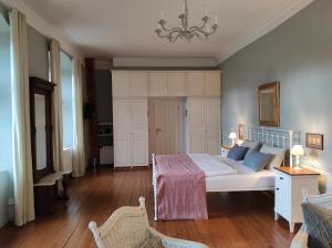 a bedroom with a bed and a chandelier at Gartenzimmer im Schloss Neuhausen in Neuhausen