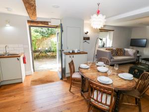 a kitchen and living room with a table and chairs at The Old Stables in Chipping Campden