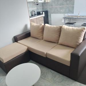 a brown couch with two pillows in a living room at Departamento Cerro Catedral in Neuquén