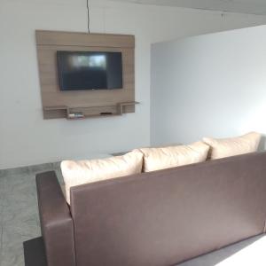 ein Wohnzimmer mit einem Sofa und einem Flachbild-TV in der Unterkunft Departamento Cerro Catedral in Neuquén