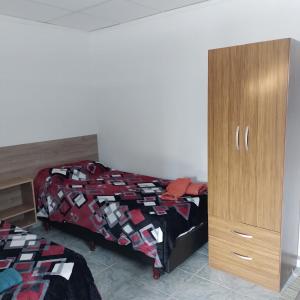 1 dormitorio con 1 cama y armario de madera en Departamento Cerro Catedral en Neuquén