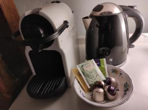 a coffee maker and a plate of food on a counter at Gartenzimmer im Schloss Neuhausen in Neuhausen