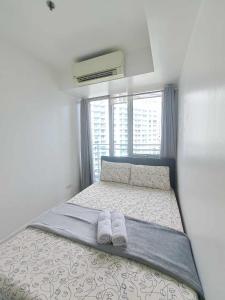 um quarto com uma cama com duas toalhas em Love Grande - 2BR AZURE URBAN em Manila
