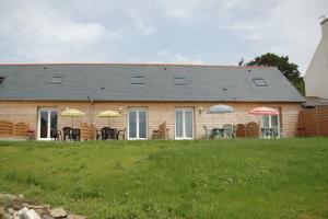 a house with tables and chairs and umbrellas at Gite Penn ar bed in Cast