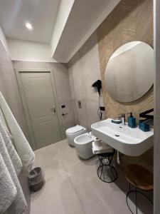 uma casa de banho com um lavatório, um WC e um espelho. em La Stella Di Napoli B&B em Nápoles