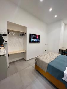 a bedroom with a bed and a tv on the wall at La Stella Di Napoli B&B in Naples