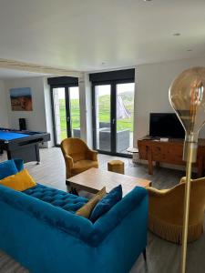 a living room with a blue couch and a pool table at Le Buron du Bessou in Saint-Urcize