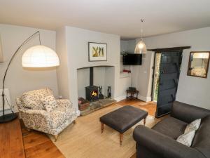 a living room with a couch and a fireplace at The Old Brewhouse in Chipping Campden