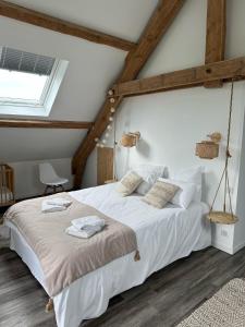 a bedroom with a bed with white sheets and a window at Le Buron du Bessou in Saint-Urcize