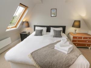 a bedroom with a large white bed with towels on it at The Old Brewhouse in Chipping Campden
