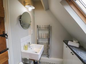 a bathroom with a sink and a mirror at The Old Brewhouse in Chipping Campden +20 photos