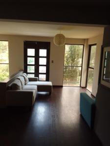 a large living room with two couches and windows at Linda casa de campo con todas las comodidades de la ciudad in Cochabamba