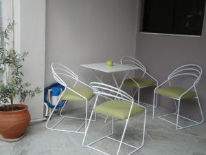 Una mesa y cuatro sillas en una habitación con una planta en Filia, en Skiathos