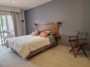 a bedroom with a bed with a wooden headboard and a chair at chez Yannick Hospedaje Los Amigos in Salento