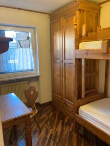 卡瓦萊塞的住宿－CASA CAVALESE，客房设有两张双层床、一张桌子和一扇窗户。
