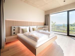 una camera da letto con un letto grande con una grande finestra di Loxone Campus a Kollerschlag