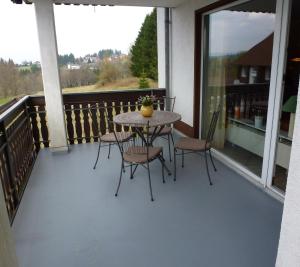 eine Terrasse mit einem Tisch und Stühlen auf dem Balkon in der Unterkunft Fewo Hexentanz in Braunlage