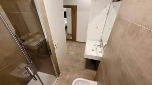 een badkamer met een douche, een wastafel en een toilet bij A Nanein con Joy in Bologna