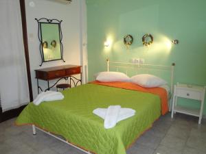 1 dormitorio con cama con espejo y lavamanos en Filia, en Skiathos