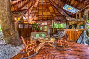 una sala de estar en una casa en un árbol con mesa y sillas en Tree House Lodge en Puerto Viejo