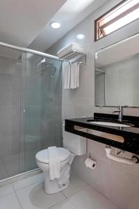 a bathroom with a toilet and a shower and a sink at Marinas Maceió Hotel in Maceió