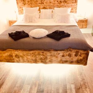 Un dormitorio con una cama de madera con dos ropas negras. en Au coeur du 11, en Beyne-Heusay