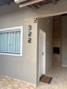 a house with a number on the wall and a door at Casa Praia&Ferias 300 metros Praia da Enseada in São Francisco do Sul