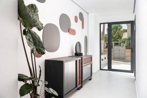 a living room with a tv and a wall with circles at Nuovo Luxury Suites in Daratso