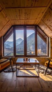 Zimmer mit einem Tisch vor einem großen Fenster in der Unterkunft Mountain house Potkovica in Lazići