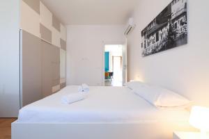 a bedroom with a white bed with two towels on it at PrimoPiano - Novara in Milan