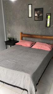 a bedroom with a large bed with pink pillows at Hostel Bombinhas in Bombinhas