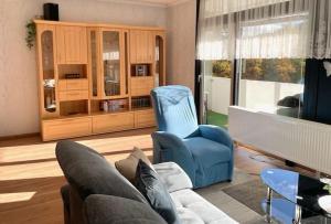 een woonkamer met een bank en een blauwe stoel bij Ferienwohnung Carpe Diem in Bad Harzburg