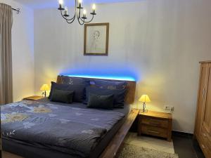 een slaapkamer met een bed met een blauw licht bij Ferienwohnung Stahl in Muhr amSee