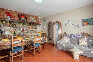a kitchen and living room with a table and a couch at La Bella Toscana Ulivo Apartment in Monsummano Terme