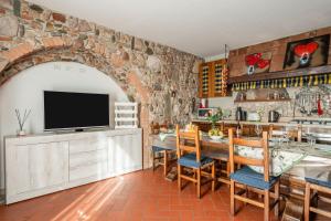 a kitchen with a stone wall and a table with chairs at La Bella Toscana Ulivo Apartment in Monsummano Terme