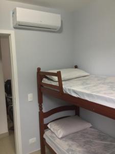 a room with two bunk beds with a air conditioner at Apto. aconchegante in Ubatuba +19 photos