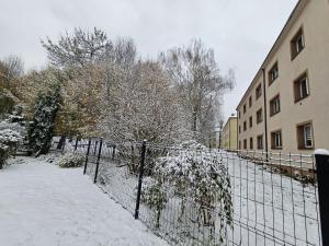 a fence covered in snow next to a building at Eddie's Luxury Apartments in Gliwice