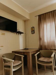 a room with a table and two chairs and a television at Kristina in Novi Sad