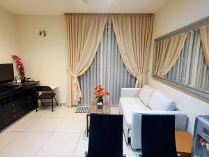 uma sala de estar com um sofá e uma mesa em Central Park Residence Podomoro Condo for Four em Jakarta