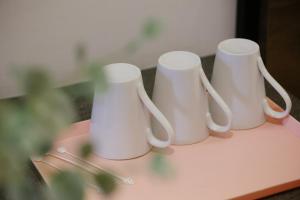 three white cups sitting on top of a table at Kangsar Inn 73 in George Town