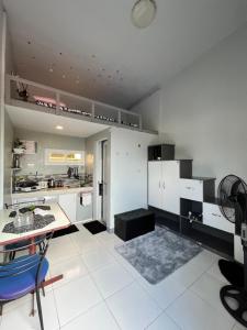 Una cocina con gabinetes blancos y una mesa y sillas azules. en JC Unit #7, en Urdaneta 14 fotos más