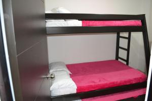 a room with two bunk beds with pink sheets at GURUS FR | NUEVO apto especial para familia in Pereira