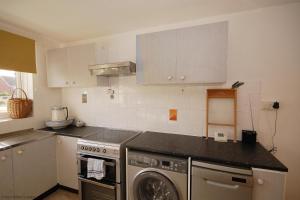 a kitchen with a dishwasher and a washer at Berry Cottage in Sheringham