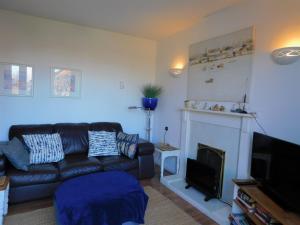a living room with a couch and a fireplace at Berry Cottage in Sheringham