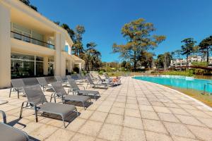 - un groupe de chaises assises à côté de la piscine dans l'établissement Oceana Suites en Green Park, playa Solanas, à Punta del Este