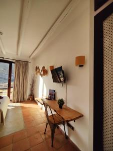 a living room with a wooden table and a window at Cortijo El Paraíso in Los Escullos