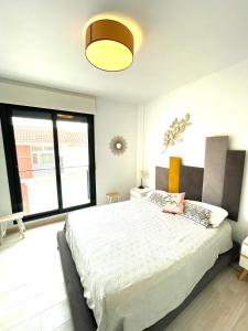 ein Schlafzimmer mit einem großen Bett und einem großen Fenster in der Unterkunft Luxury and Modern Beach Apartment with Sea Views in La Mata